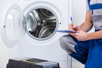 Plumber inspecting washing machine fault 